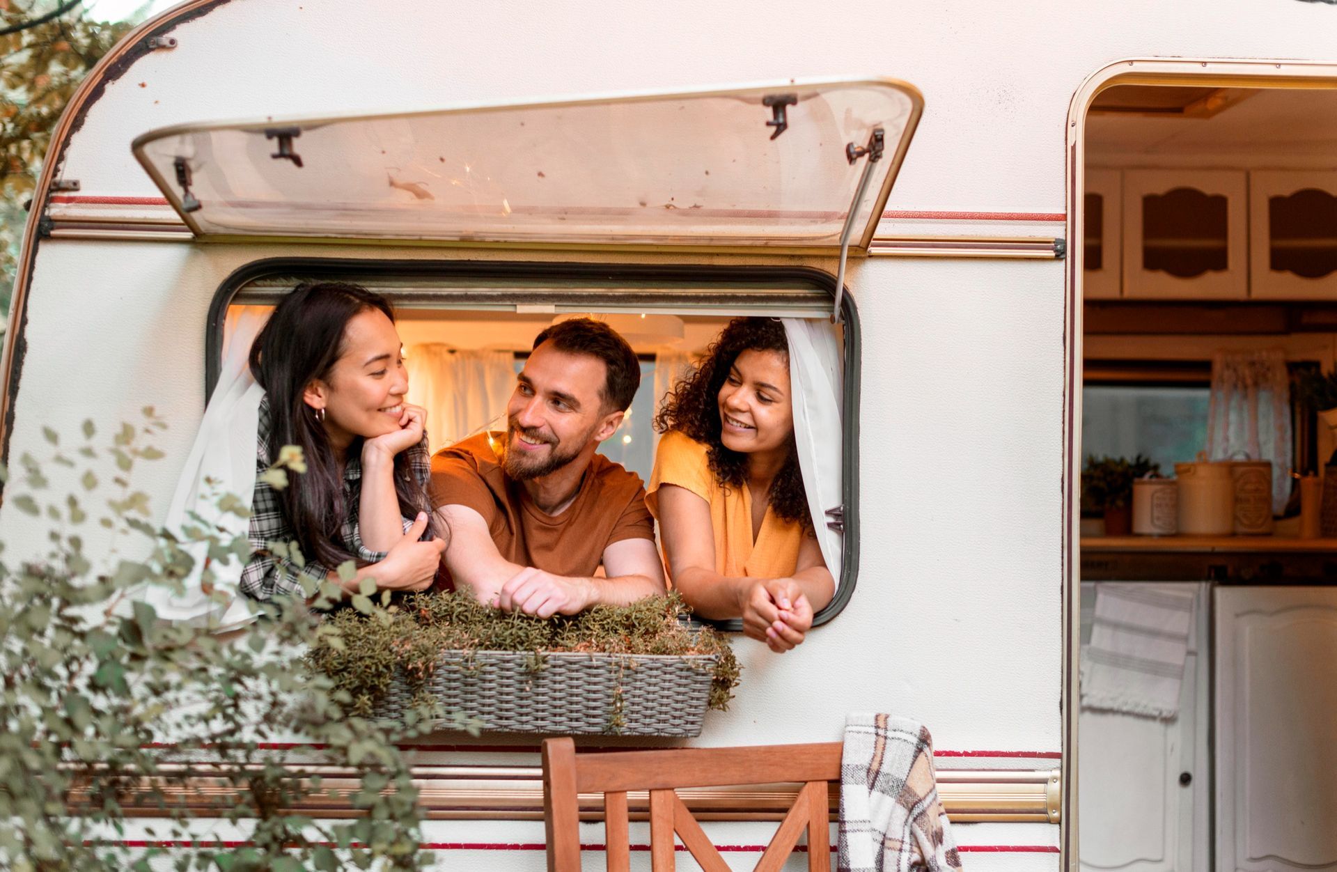 A group of people are looking out of the window of a camper.