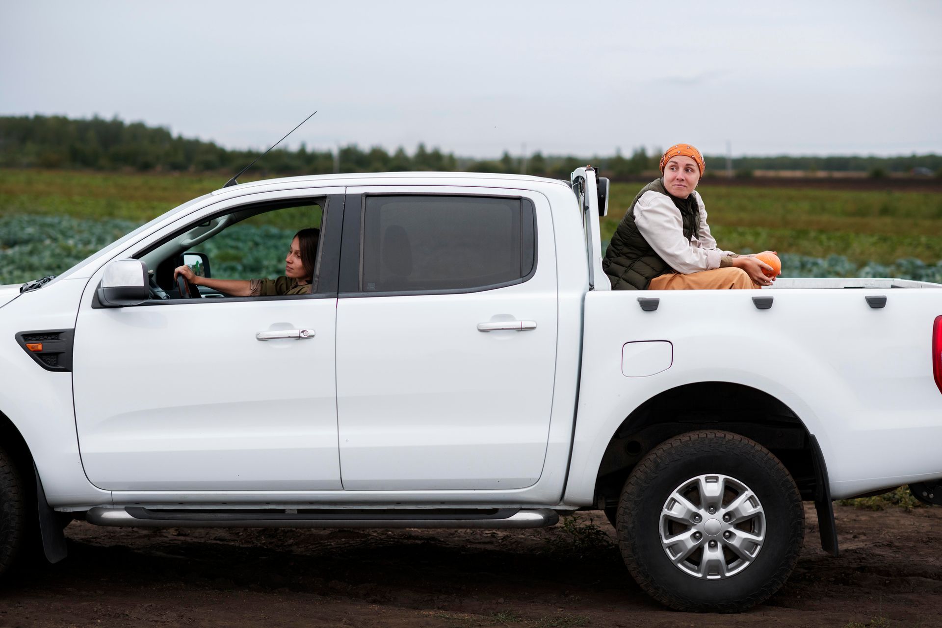 A person is sitting in the back of a white truck.