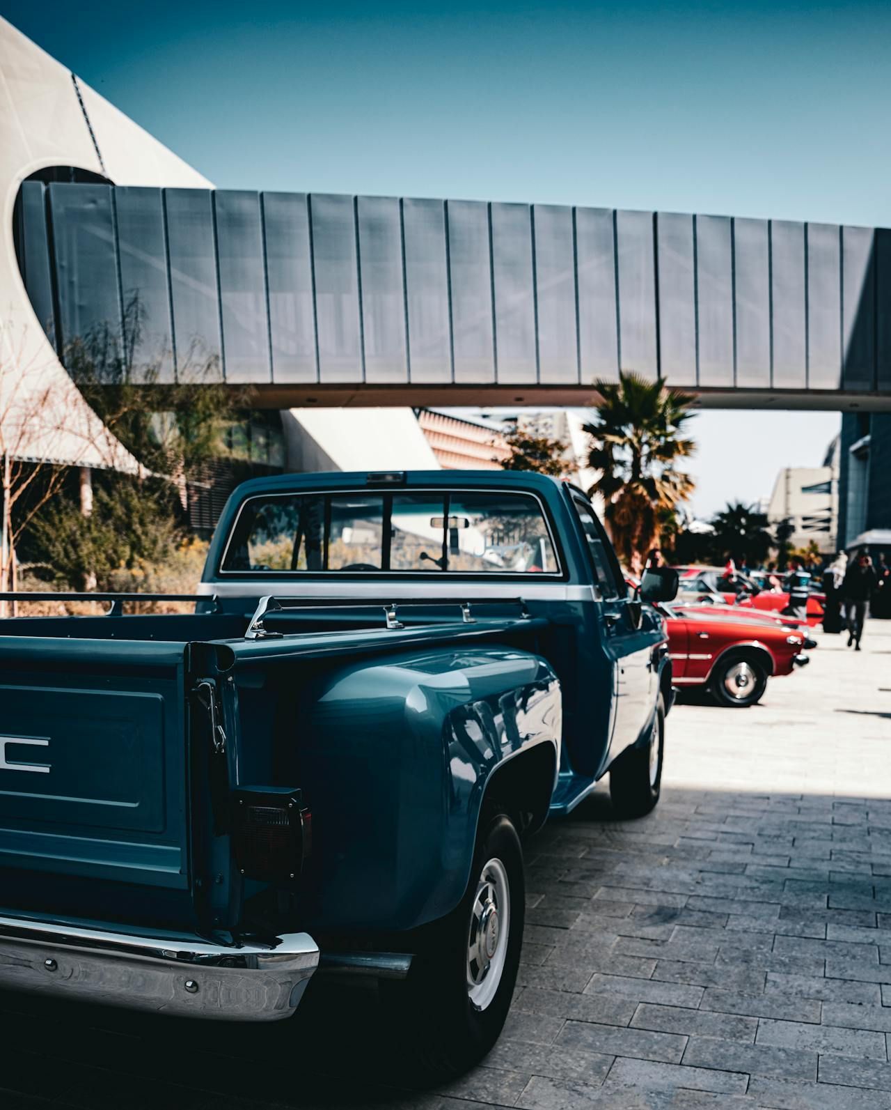 A blue pickup truck is parked in front of a building.