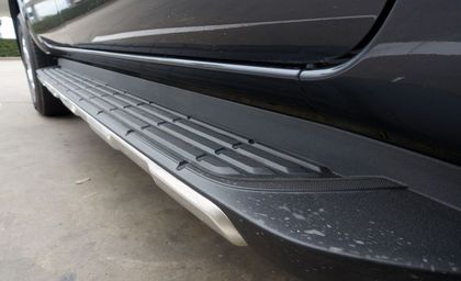 A close up of a car 's side step on a parking lot.