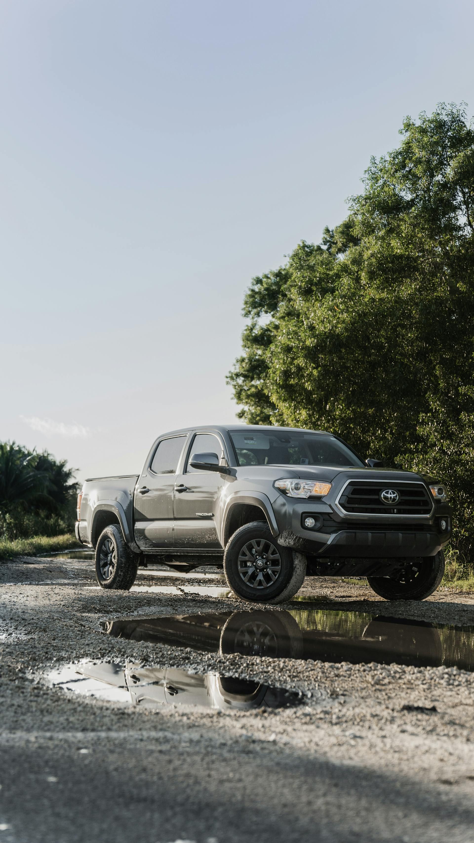 A toyota tacoma truck is parked on a muddy road.