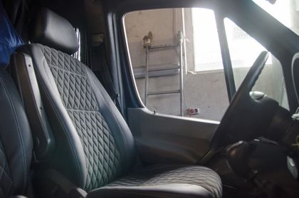The interior of a pickup truck with a black seat and a steering wheel.