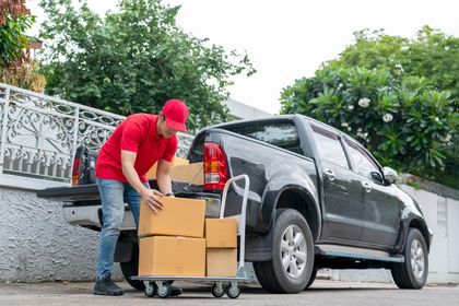 Man loading boxes on a pickup truck bed