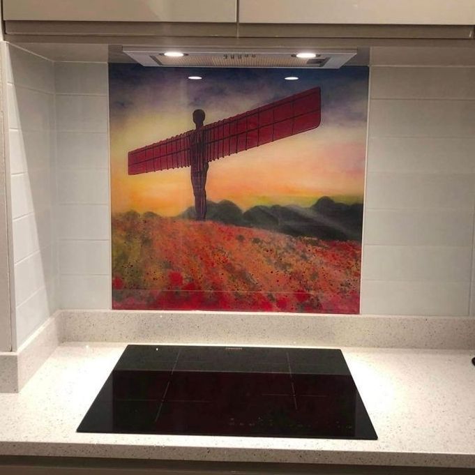 Murals of the Angel of the North above a black basin in a white tiled niche