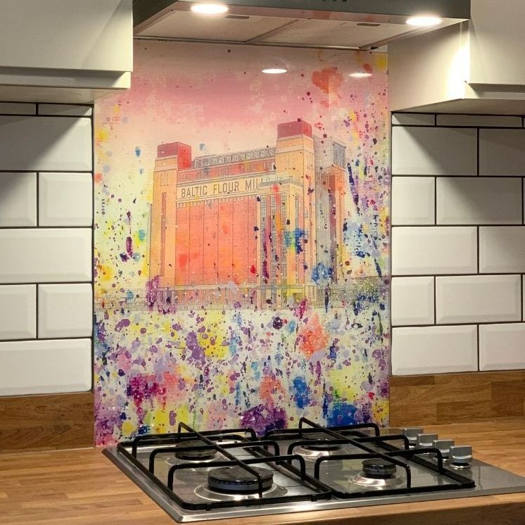 Colorful abstract painting leaning behind a stovetop in a tiled kitchen.