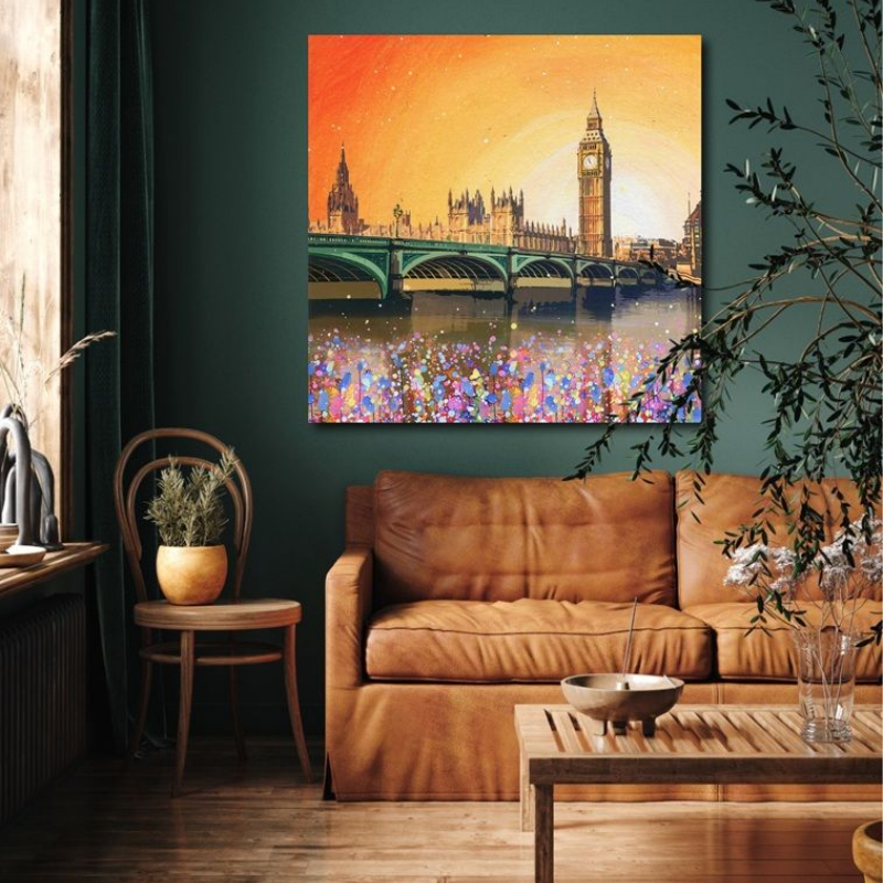 Cozy living room with tan sofa, wooden table, and colorful cityscape painting above the couch