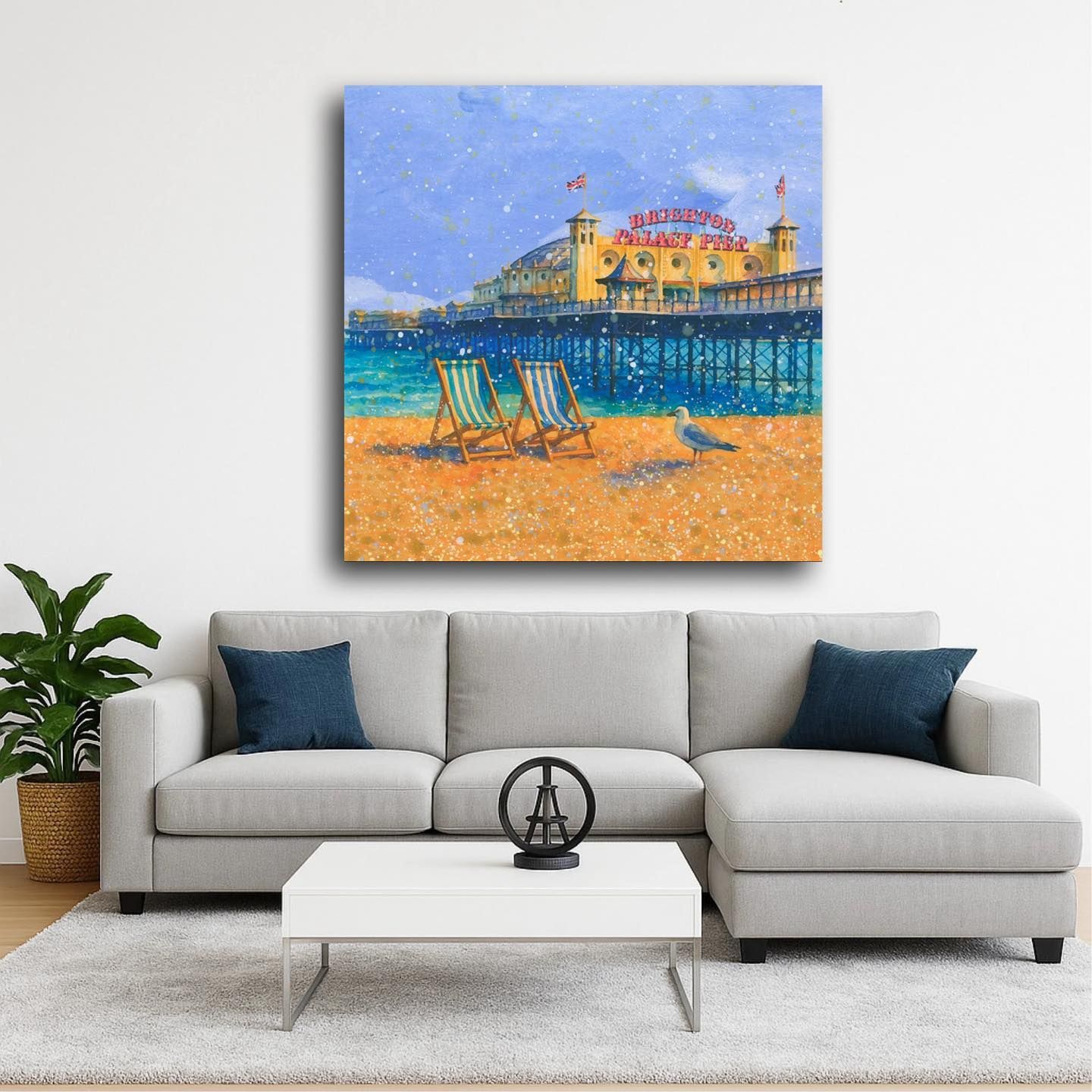 Modern living room with gray sectional and a seaside painting above a coffee table