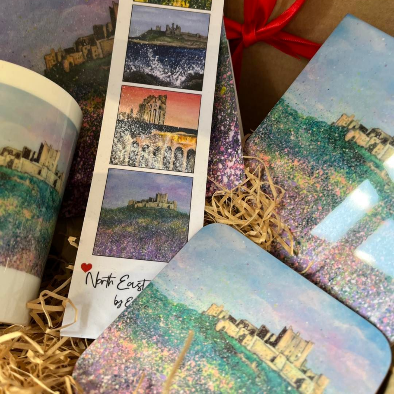 Photo collage cards and a notebook with scenic city prints, arranged on straw with a red ribbon.