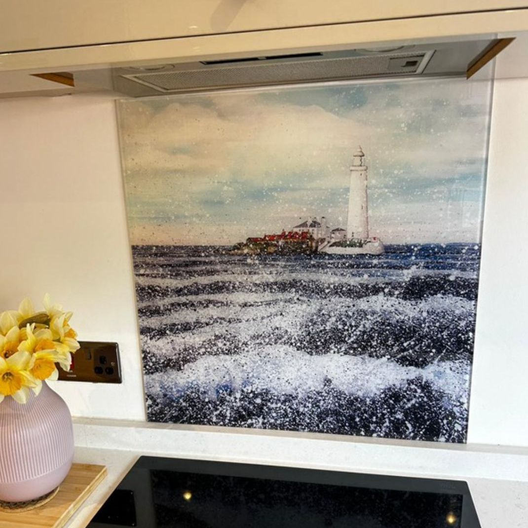 Framed lighthouse painting above a mantel with yellow flowers in a pink vase