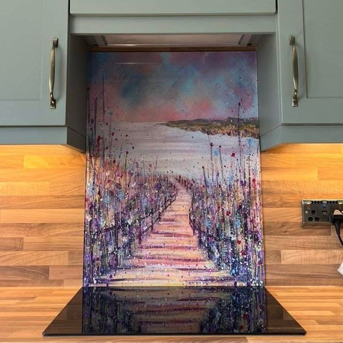 Colorful abstract painting of a staircase and path displayed in a kitchen nook under cabinets.