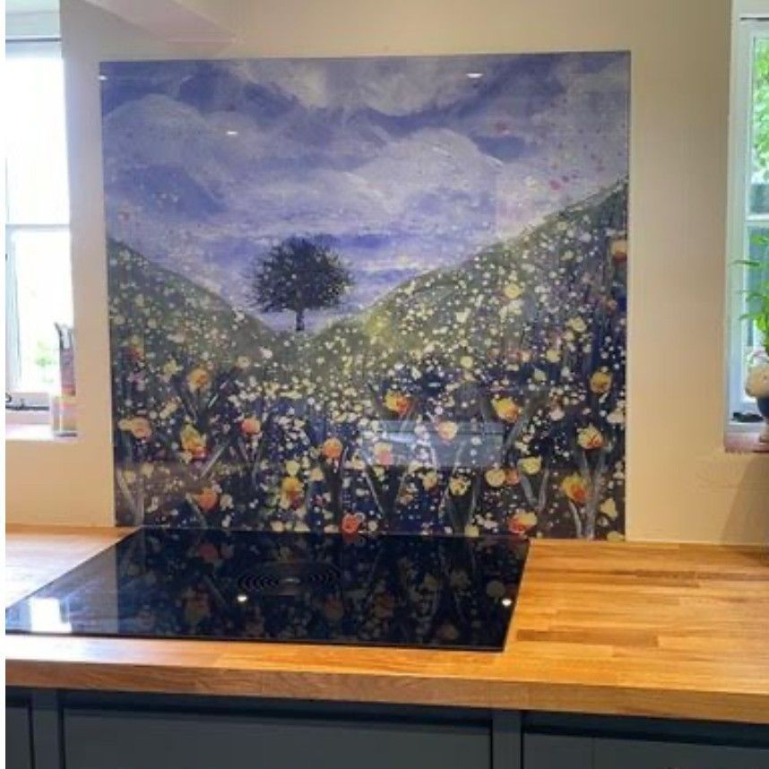 Kitchen counter with black cooktop and a large floral landscape mural backsplash behind it