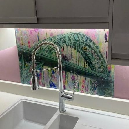 Modern kitchen sink with chrome faucet in front of a green arched bridge mural