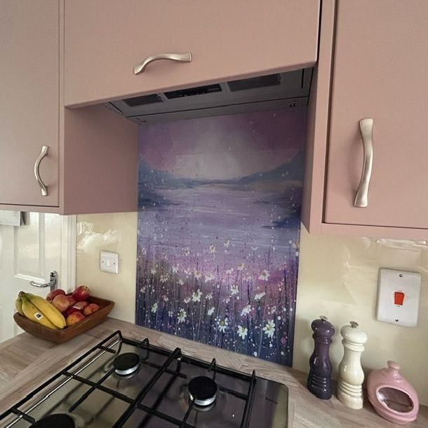 Kitchen stove with pink cabinets and a purple floral backsplash panel