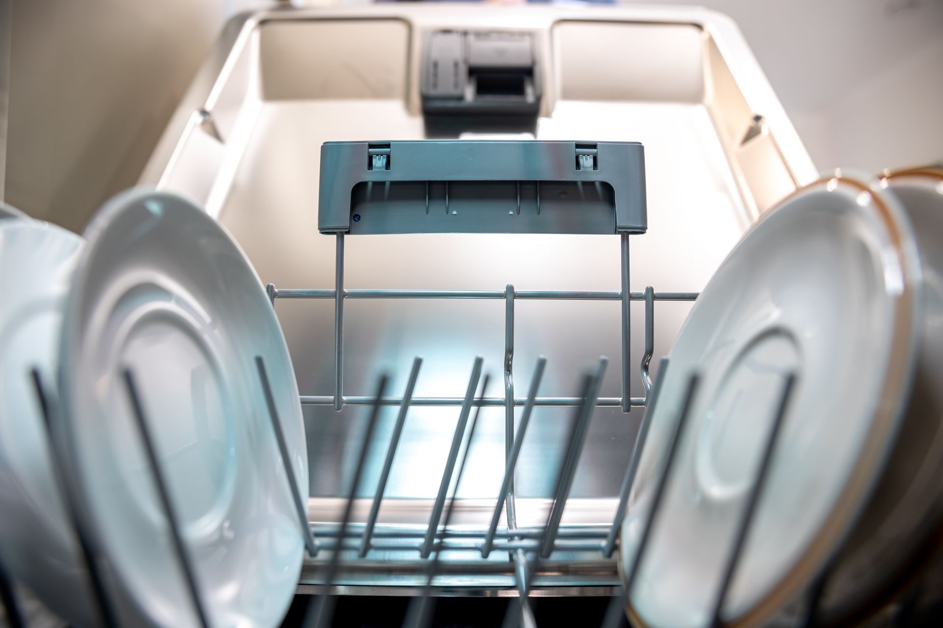 Open dishwasher with clean dishes and racks inside