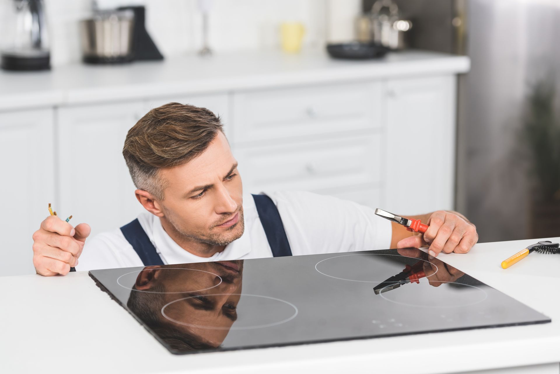 technician repairing stove top and range