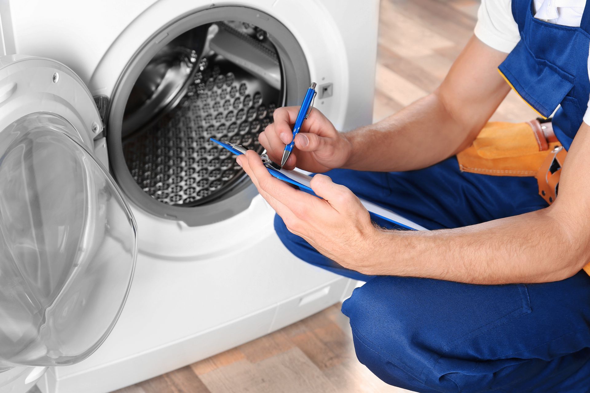 technician performing repairs to dryer