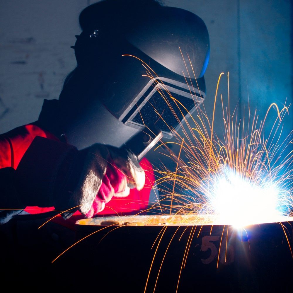 A Man Wearing A Welding Helmet Is Welding A Piece Of Metal — Kaplan Engineering Pty Ltd In Bowen, QLD