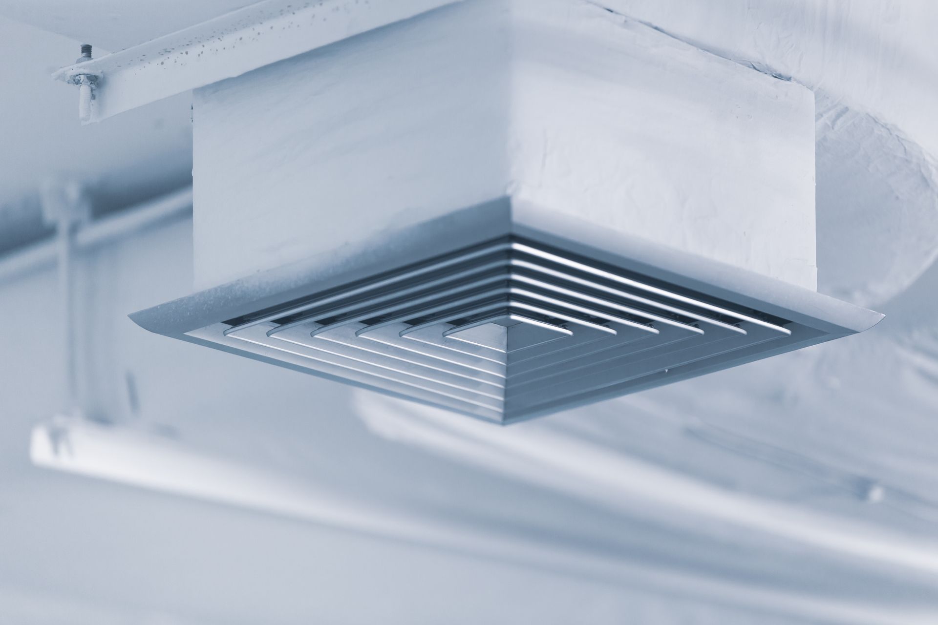A close up of an air vent on the ceiling of a building.
