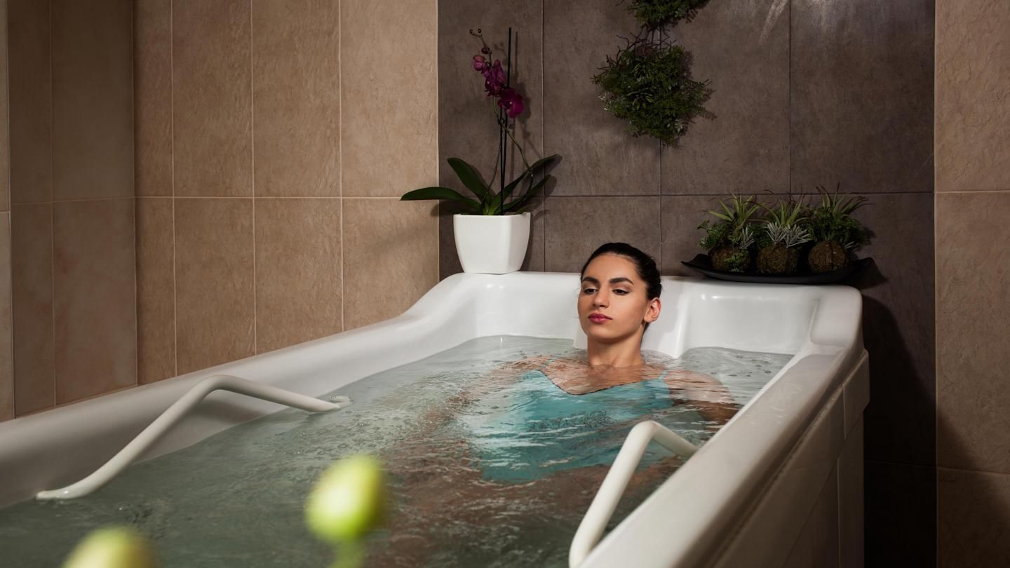 Une femme prend un bain dans une baignoire dans un spa.