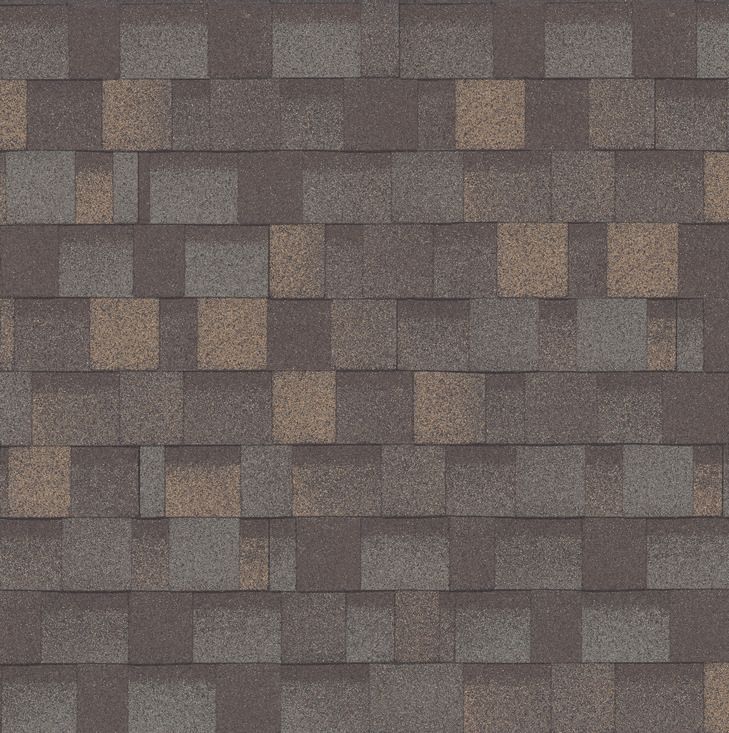 A close-up view of architectural roof shingles in a multi-toned blend of grey, charcoal, and warm brown shades.