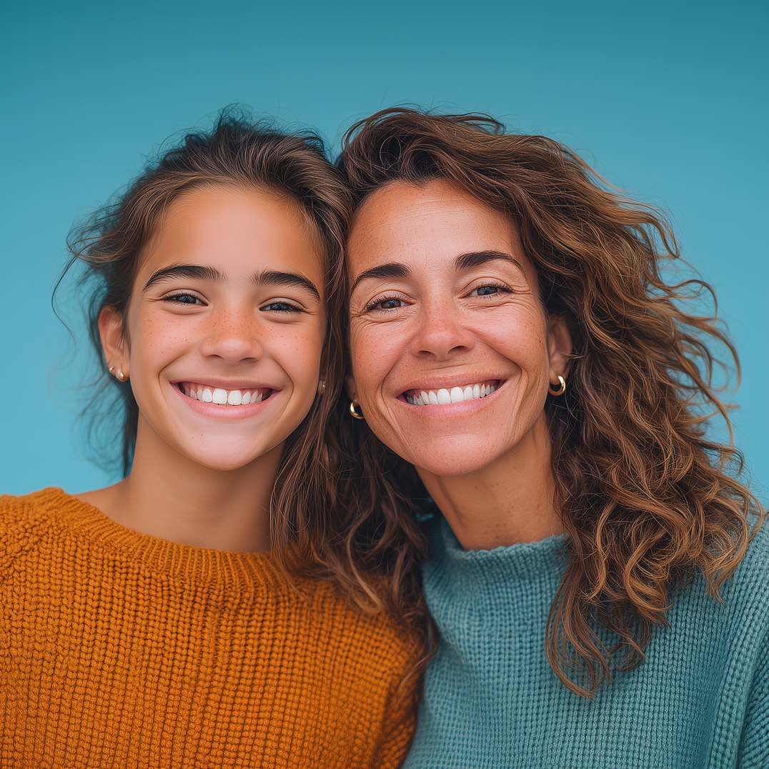 Woman and child smiling closely together, against a blue background. The woman has brown curly hair and a teal sweater. The child has brown hair and an orange sweater.