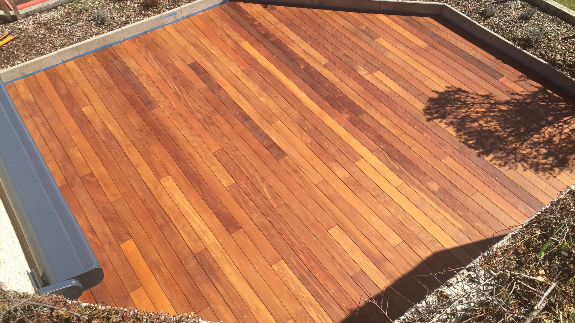 A wooden deck with a reflection of a tree in it