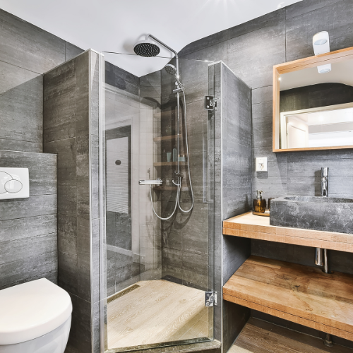 A bathroom with a toilet , sink , shower and mirror