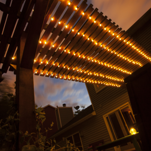 A pergola with lights hanging from it is lit up at night