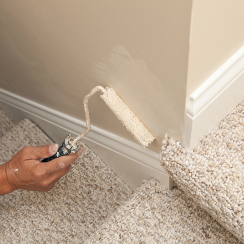 A person is painting a wall with a roller