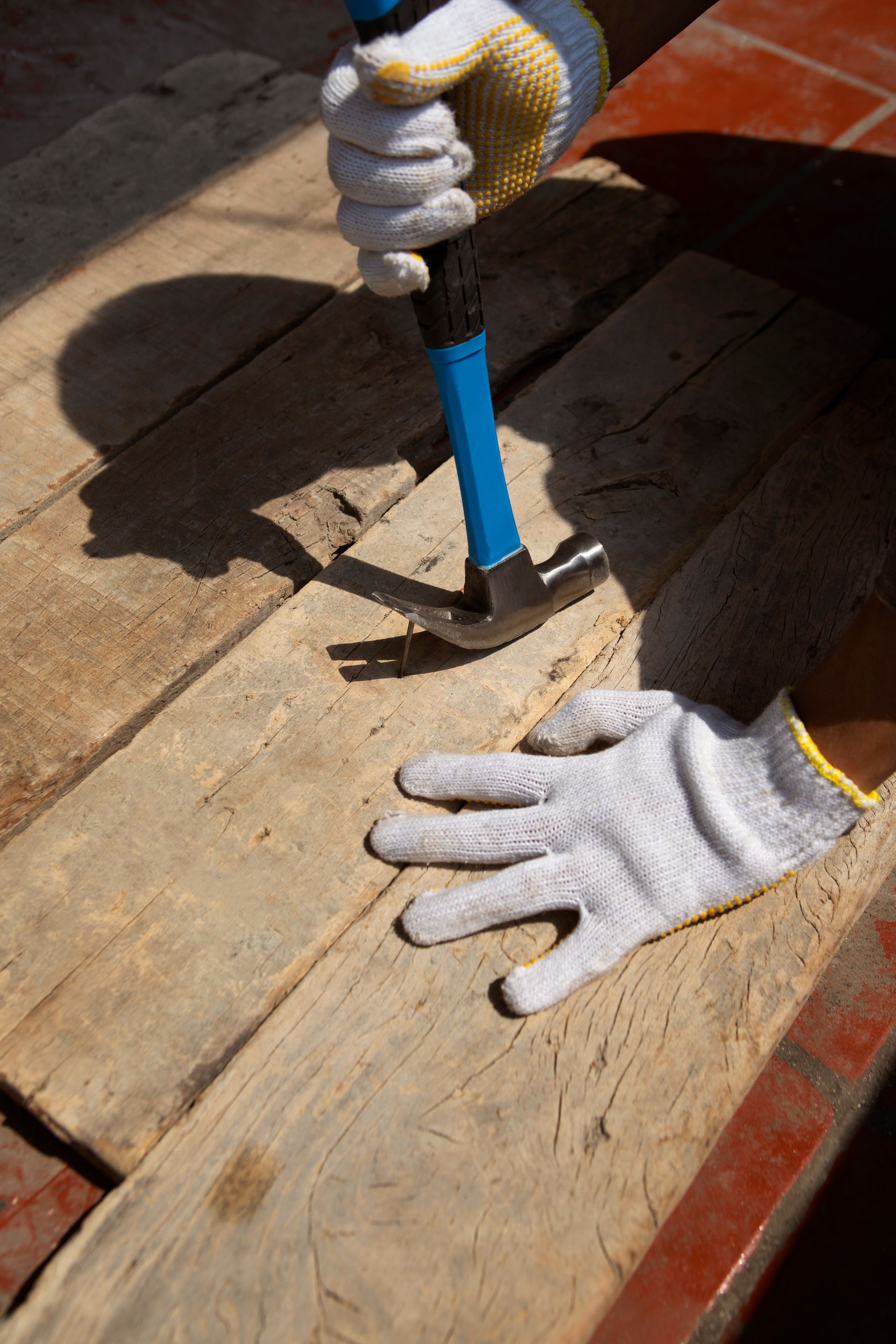 A person is hammering a nail into a piece of wood.