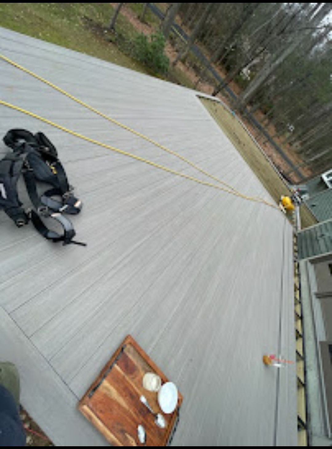 A backpack is laying on top of a wooden deck.