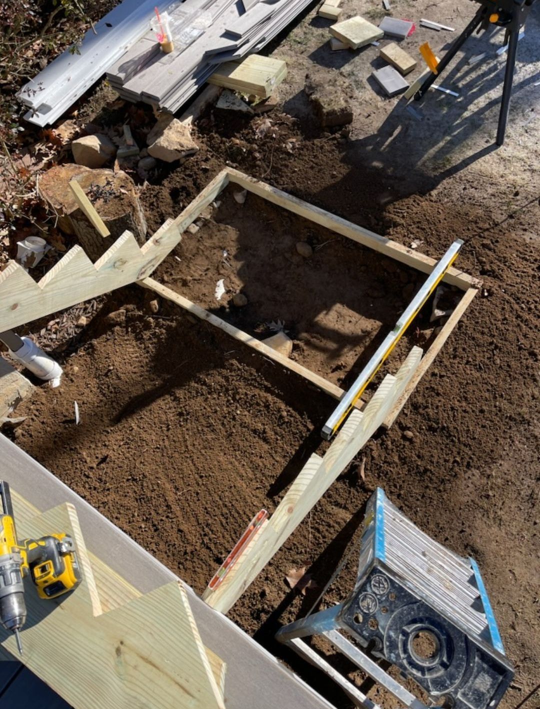 A wooden staircase is being built in the dirt