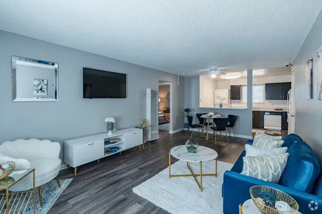 Blue-themed living room with a sofa, TV, and dining area visible in the backgroundat Reno Vista Apartments.