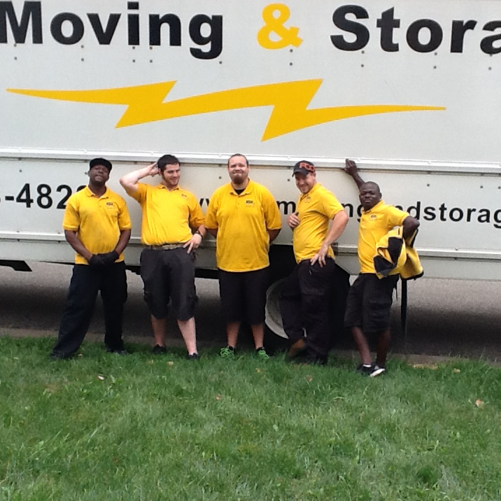 A group of men standing in front of a moving and storage truck
