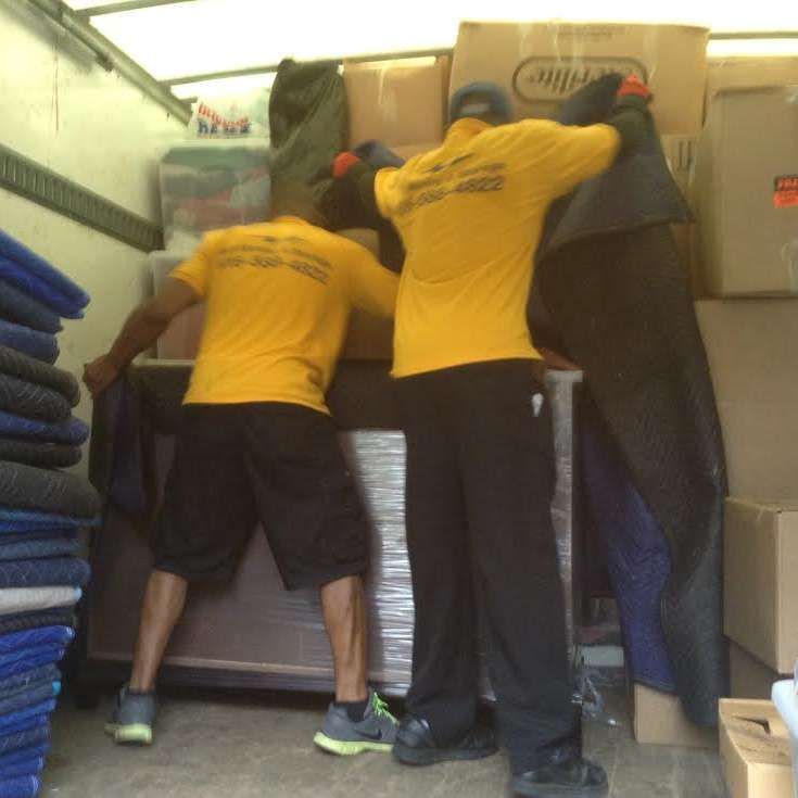 A man wearing a yellow shirt that says ' moving company ' on it