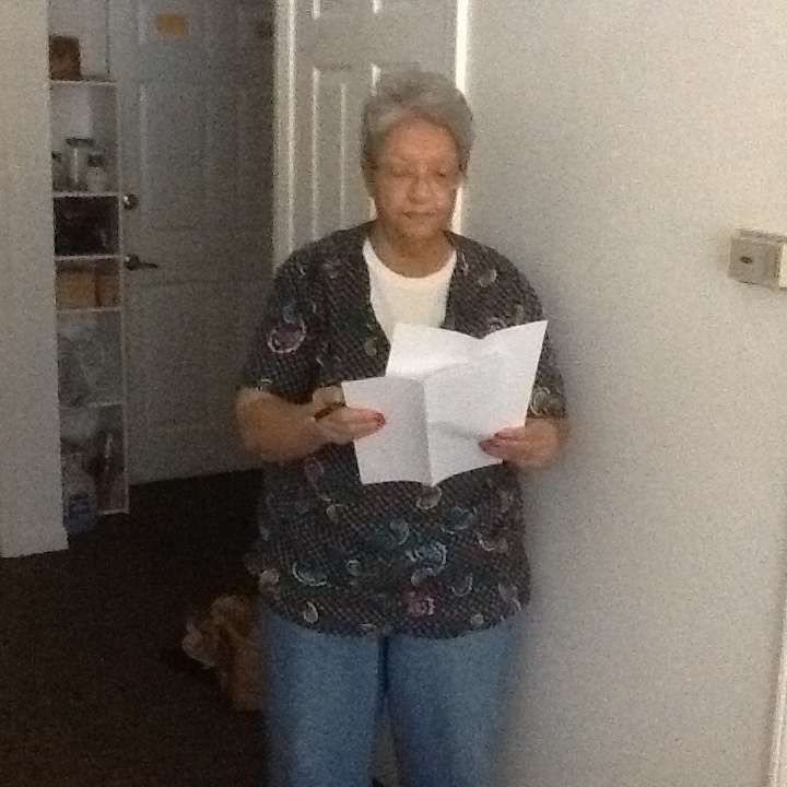 A woman standing in a doorway holding a piece of paper