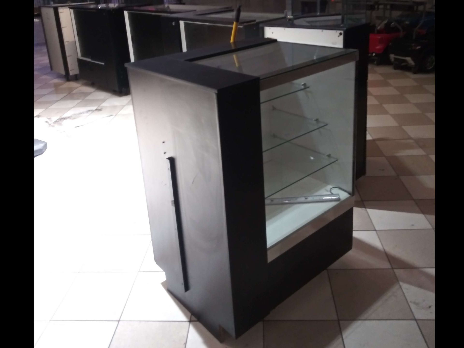 A glass display case is sitting on a tiled floor