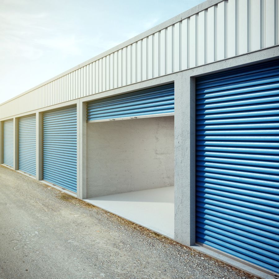 A row of storage units with blue roller doors.