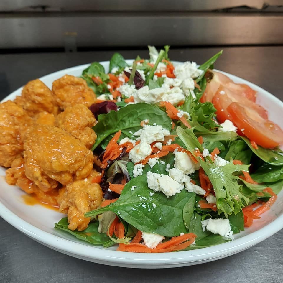 Buffalo cauliflower with salad: greens, carrots, feta, tomato.