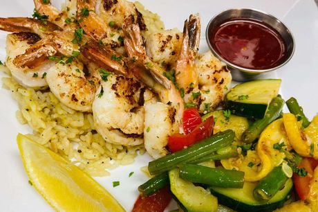 Grilled shrimp with rice, vegetables, and dipping sauce.