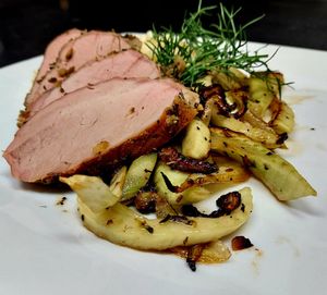 Sliced pork tenderloin with roasted fennel and herbs.