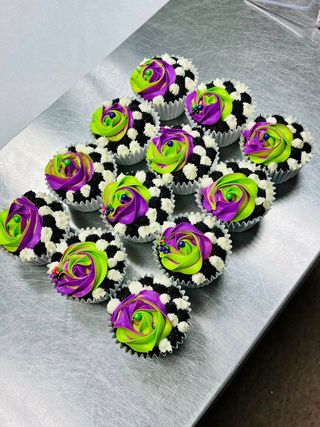 Cupcakes with checkerboard frosting and swirled green and purple icing roses.