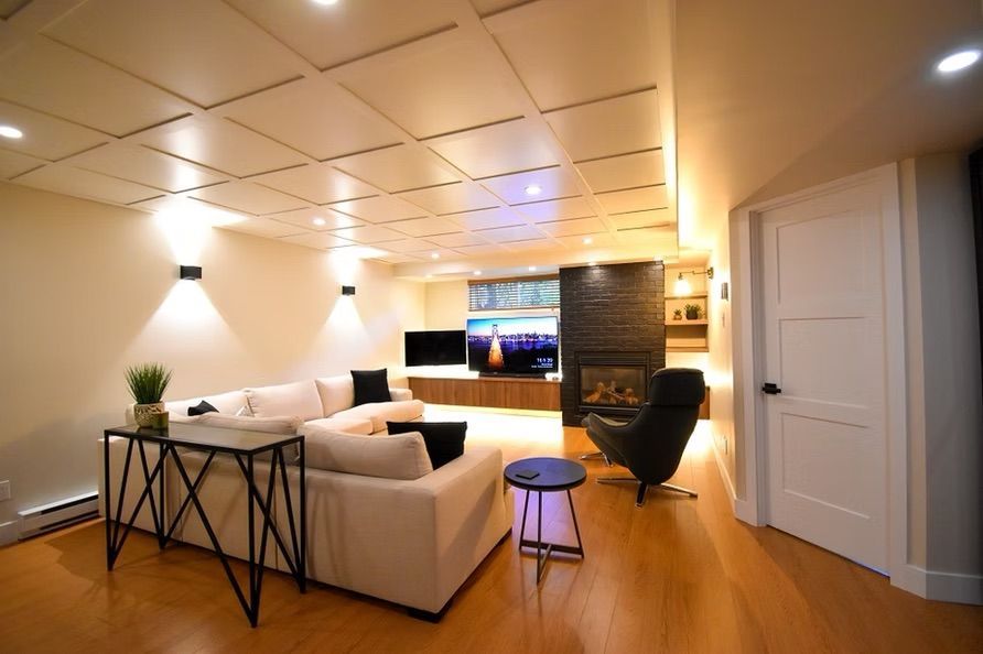 Salon moderne avec canapé d'angle blanc, cheminée et parquet.
