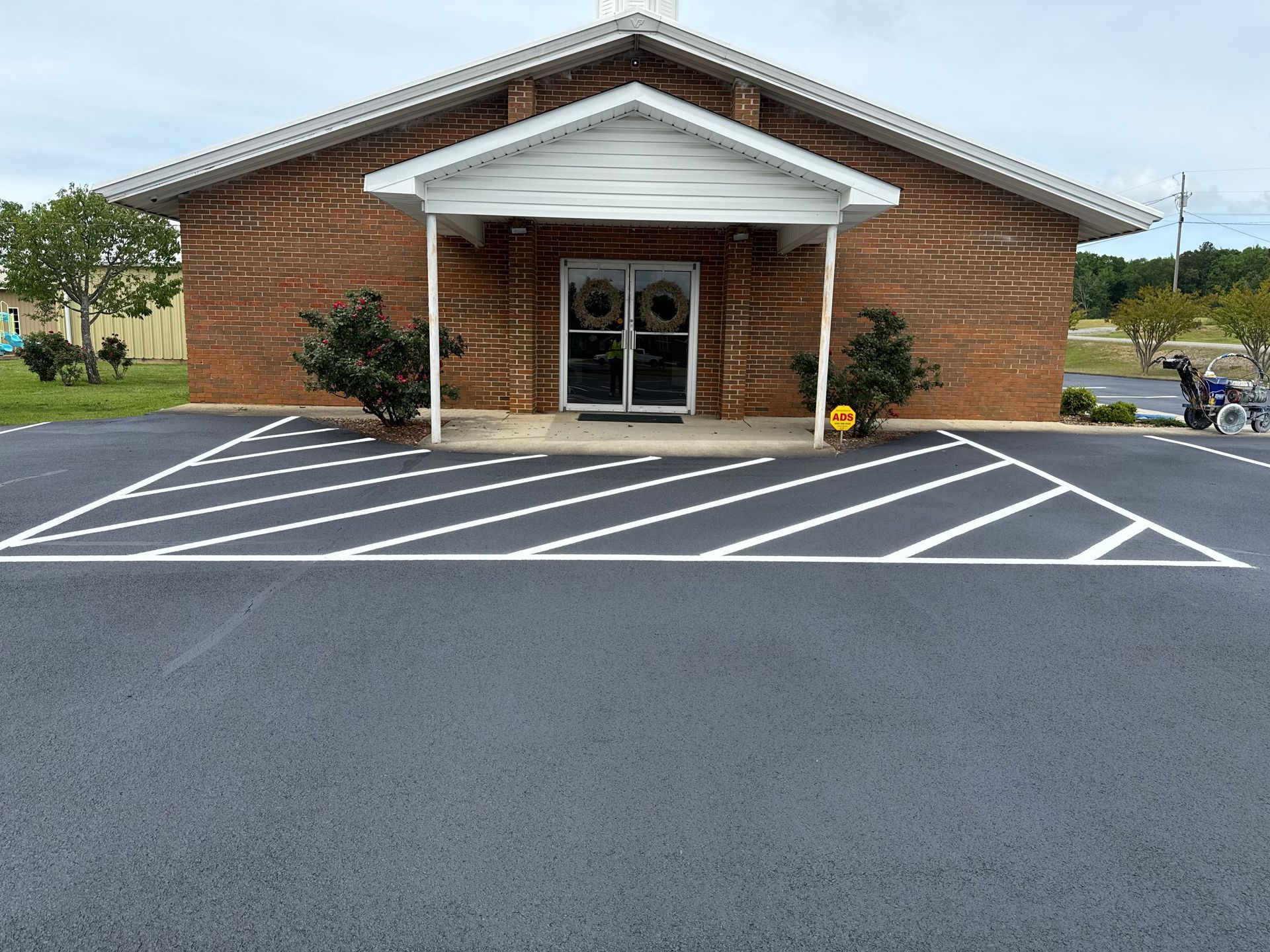 Church entrance with a freshly paved parking lot and angled parking spaces.