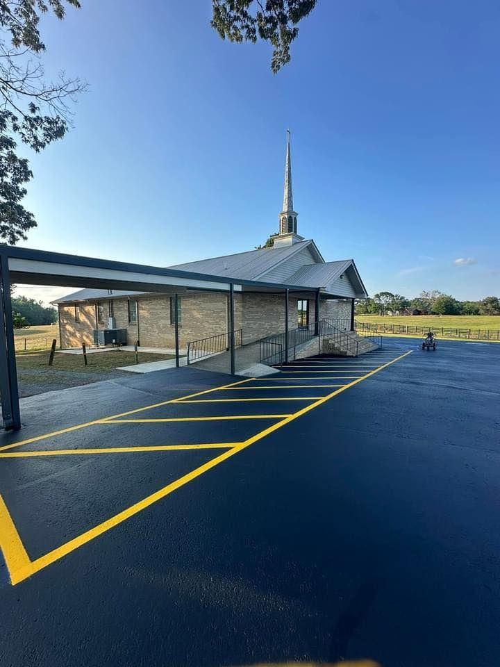 Church building with steeple and adjacent parking lot with yellow markings.