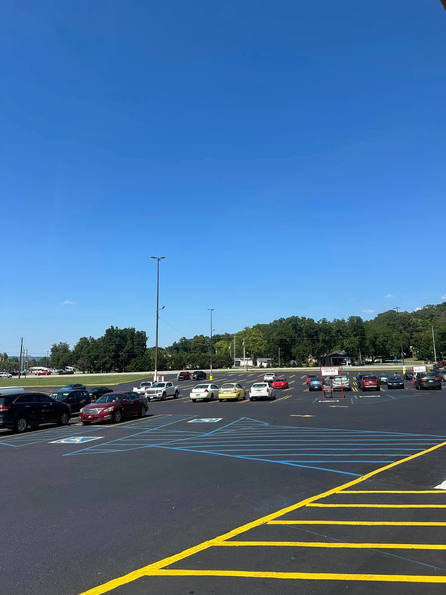 Parking lot with cars under a bright blue sky.