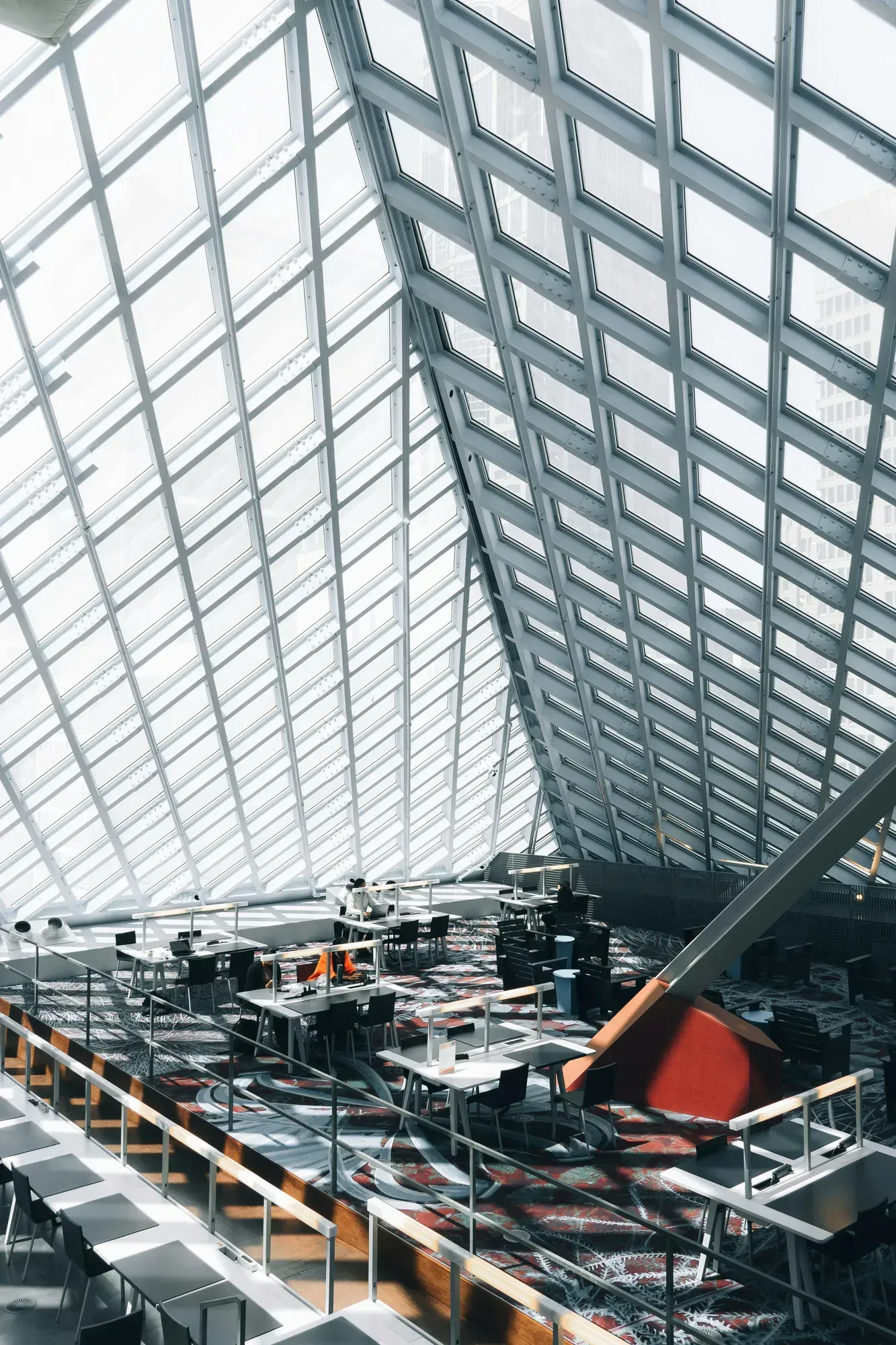 Modern glass atrium with steel beams and rows of aircraft and equipment below