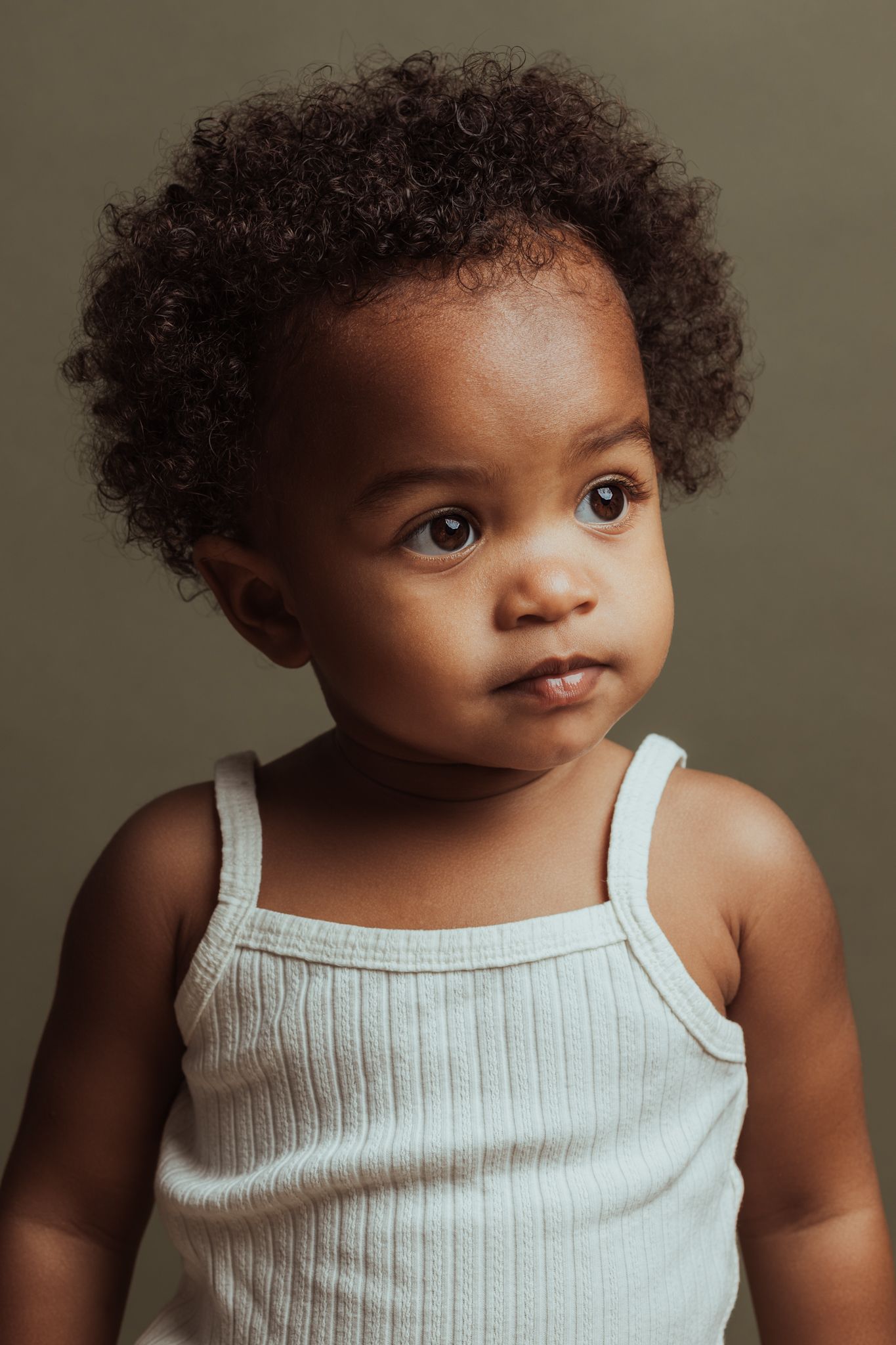 Natuurlijk kinderportret van een meisje met kort krullend haar in een fotostudio in Amersfoort