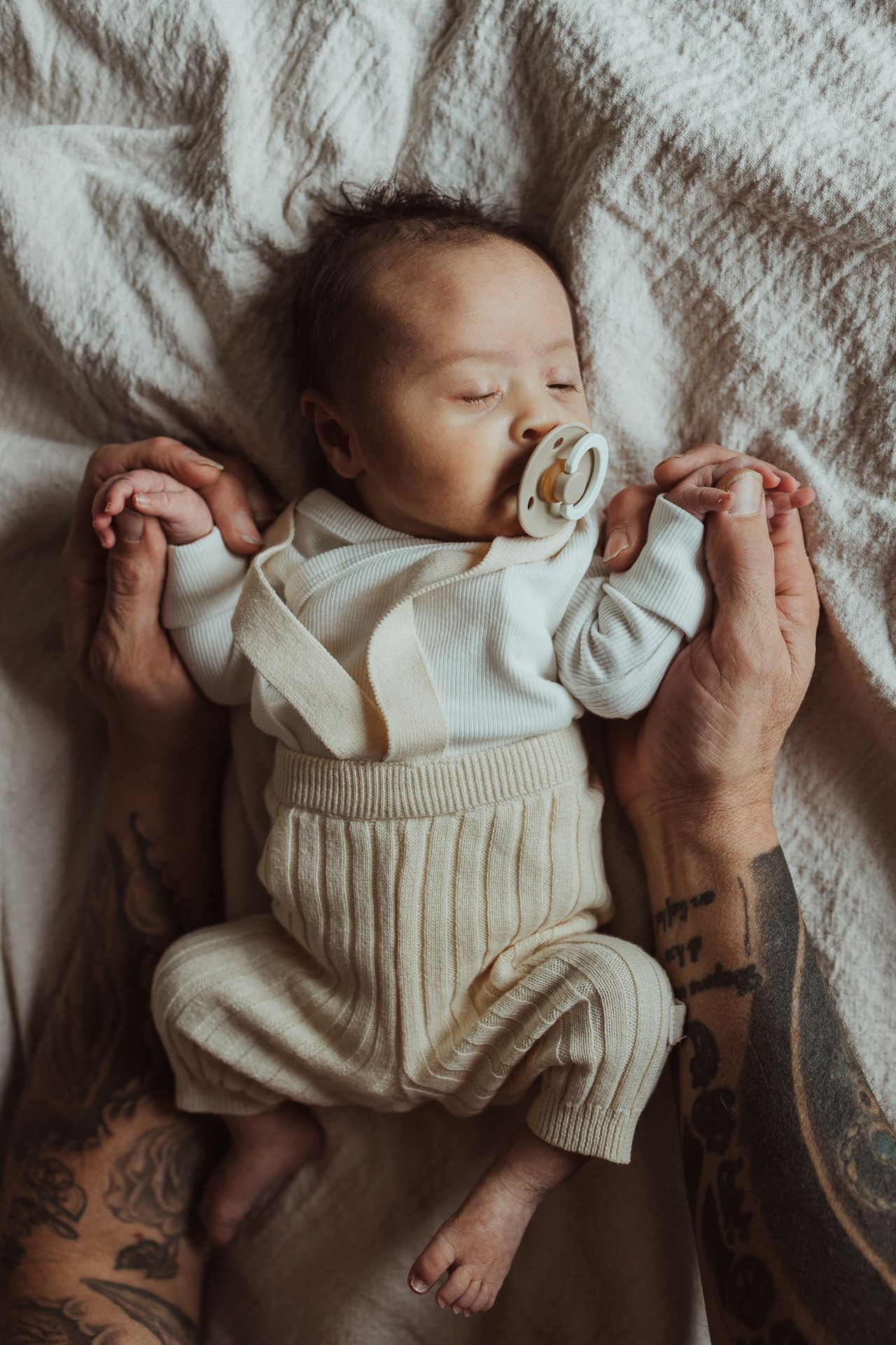 Newborn houdt de handen van papa vast tijdens newbornshoot bij Sibbe fotografie.