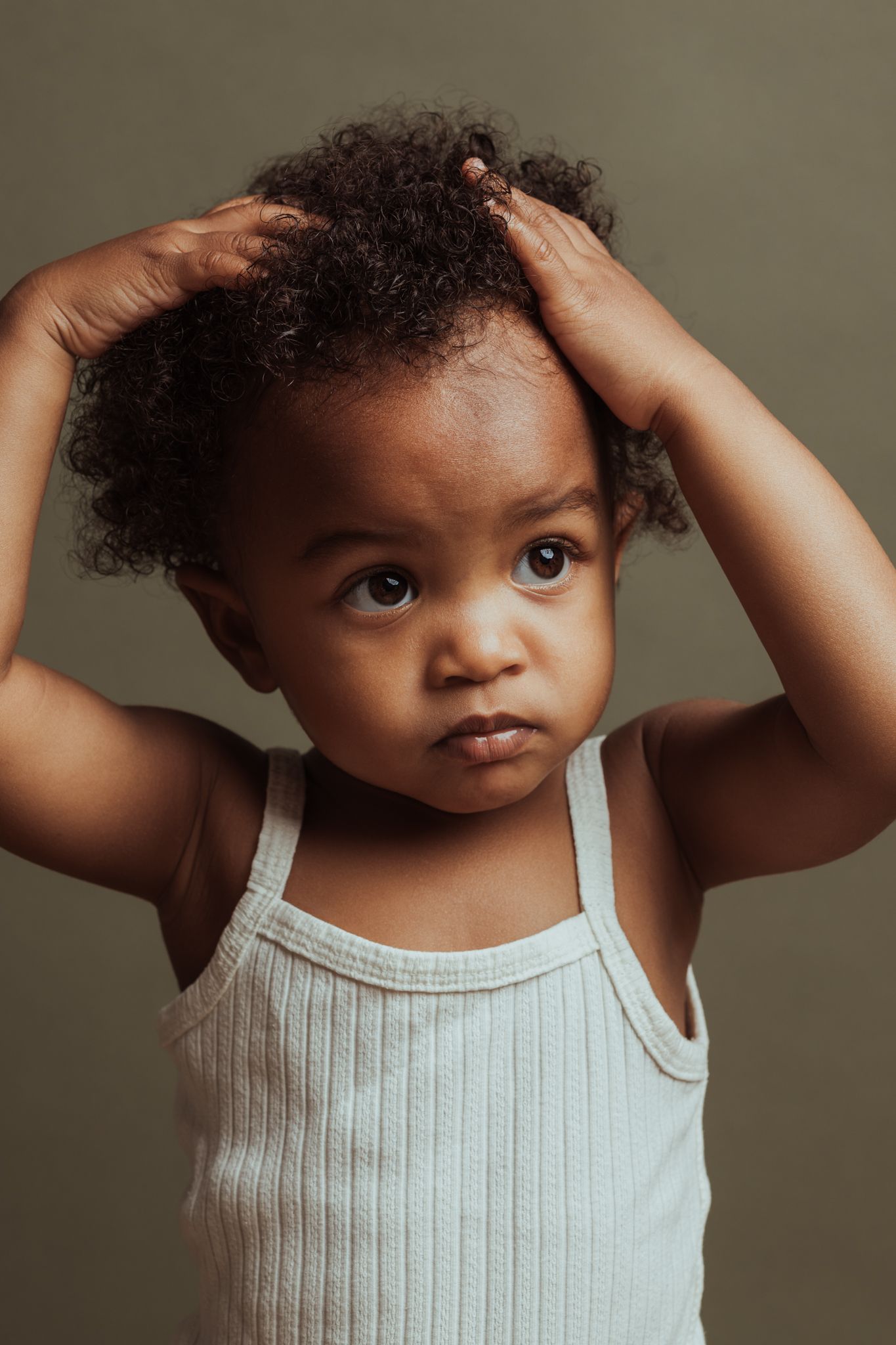Kinderportret van meisje met de handjes in het haar in fotostudio in Amersfoort